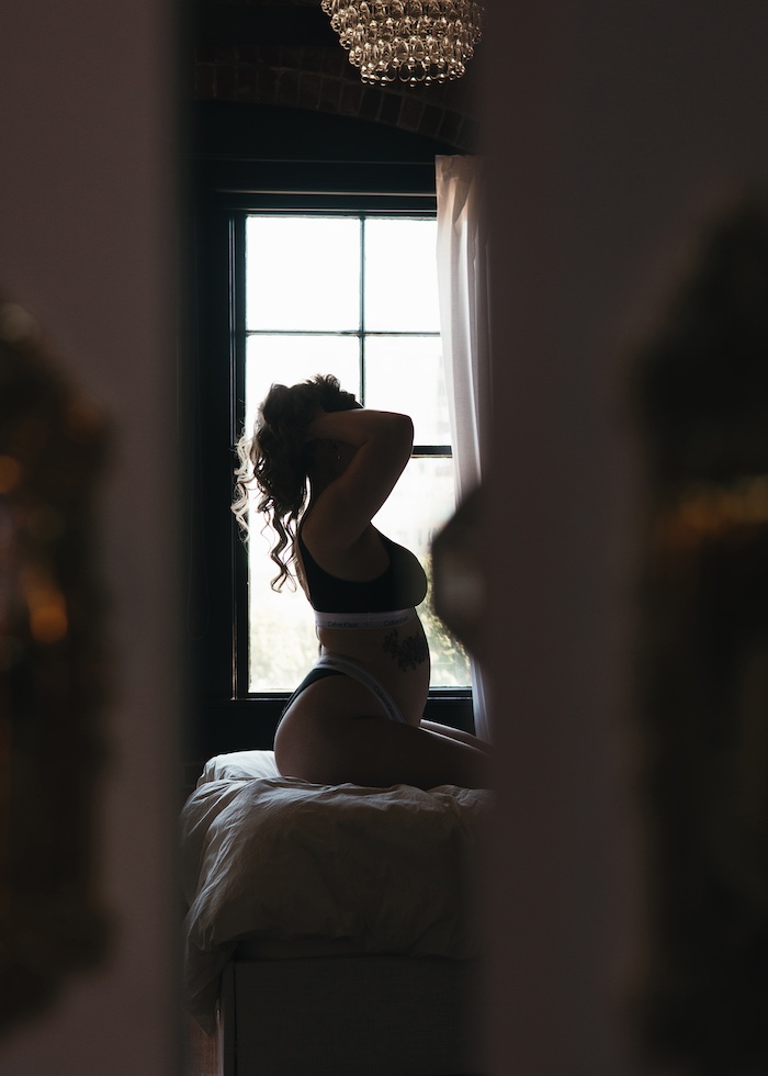 silhouette of a woman posing in front of a window