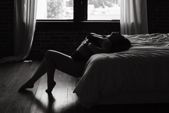 photo of a woman in a boudoir pose on a bed in a portland oregon boudoir photography studio